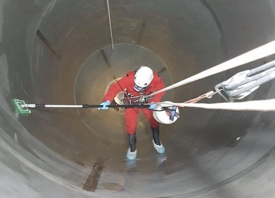 technician cleaning inside of silo